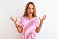 Young redhead woman wearing striped casual t-shirt stading over white isolated background crazy and mad shouting and yelling with Royalty Free Stock Photo