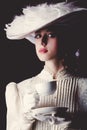 Woman in white Victorian era clothes with cup of tea Royalty Free Stock Photo