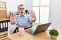 Young redhead woman working at the office using computer laptop doing stop gesture with hands palms, angry and frustration Royalty Free Stock Photo