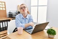 Young redhead woman working at the office using computer laptop looking at the camera blowing a kiss on air being lovely and sexy Royalty Free Stock Photo