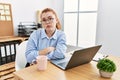 Young redhead woman working at the office using computer laptop looking sleepy and tired, exhausted for fatigue and hangover, lazy Royalty Free Stock Photo