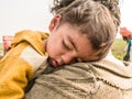 A young refugee child is sleeping on the shoulder of his father and both looks so tired hungry and terrified