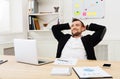 Young relaxed businessman with laptop in modern white office Royalty Free Stock Photo