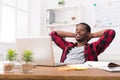 Young relaxed businessman with laptop in modern white office Royalty Free Stock Photo