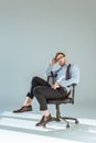 Young relaxed businessman sitting on chair on light Royalty Free Stock Photo