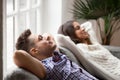 Young relaxed couple resting on comfortable couch together at home