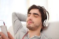 Young relaxed man listenning music in the sofa Royalty Free Stock Photo