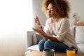 Young relaxed pensive African American woman eating healthy breakfast sitting on the couch. Copy space. Royalty Free Stock Photo