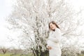 Young relaxed tender pregnant woman with closed eyes in casual clothes stroking keeping hands on belly standing in city Royalty Free Stock Photo