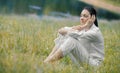 Young relaxing woman sitting in the grass