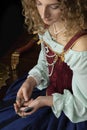 A Renaissance woman wearing a red brocade corset and blue silk skirt and holding a large key Royalty Free Stock Photo