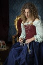 A Renaissance woman wearing a red brocade corset and blue silk skirt and holding a crucifix Royalty Free Stock Photo