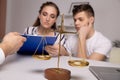 Young renters couple sitting on couch discussing renting apartment with real estate agent, focus on rental agreement and Royalty Free Stock Photo