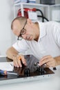 Young repair man installing kitchen hobs Royalty Free Stock Photo