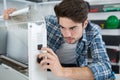 Young repairer fixing radiator at home