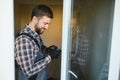 Young repairman adjusting a terrace door handle with screwdriver