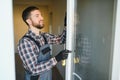 Young repairman adjusting a terrace door handle with screwdriver