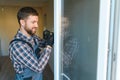 Young repairman adjusting a terrace door handle with screwdriver