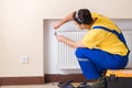 The young repairman contractor repairing heating panel