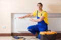 The young repairman contractor repairing heating panel