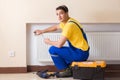 The young repairman contractor repairing heating panel