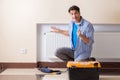 The young repairman contractor repairing heating panel