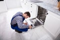 Repairman Fixing Dishwasher Royalty Free Stock Photo