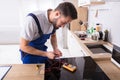 Young Repairman Fixing Induction Stove