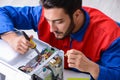 The young repairman fixing and repairing microwave oven