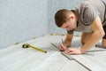 Young repairman is markup a wooden panel with a pencil and ruler before cutting Royalty Free Stock Photo