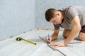 Young repairman is markup a wooden panel with a pencil and ruler before cutting Royalty Free Stock Photo