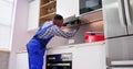 Young repairman repairing kitchen extractor filter