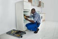 Young Repairman Repairing Refrigerator