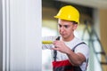 The young repairman with tape measure working on repairs Royalty Free Stock Photo