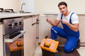 The young repairman working at the kitchen