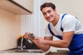The young repairman working at the kitchen Royalty Free Stock Photo