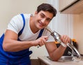 Young repairman working at the kitchen