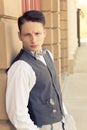 Young retro male model posing outdoors by the wall