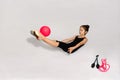 Little gymnast is doing exercise with ball on floor Royalty Free Stock Photo
