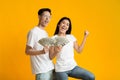 Young rich asian man and woman holding money