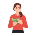 Young rich woman holding dollar bills in hands excited with win or promotion.