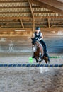 Pretty young girl doing equestrian show jumping on her pony in a farm Royalty Free Stock Photo