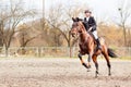 Young rider girl on horse trotting on show jumping Royalty Free Stock Photo