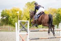 Young rider girl jumping over barier on her course Royalty Free Stock Photo