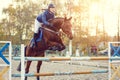 Young rider girl at show jumping. Jump hurdle