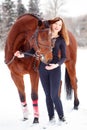 Young rider girl stand with horse in winter park Royalty Free Stock Photo