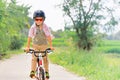 Young rider kid in helmet and sunglasses riding bicycle