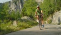 Young road biker speeding down the picturesque forest road on his new bicycle. Royalty Free Stock Photo