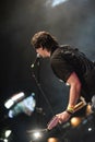 Young rock musician on stage playing guitar.