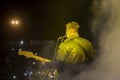 Young rock musician on stage playing guitar.